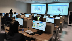 บรรยากาศผู้เข้ารับการอบรมตั้งใจปฏิบัติกิจกรรมฝึกทักษะการใช้งาน Canva ผ่านเครื่องคอมพิวเตอร์อย่างพร้อมเพรียง