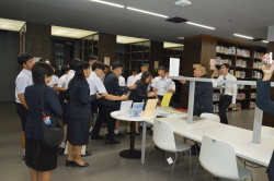 ผู้เยี่ยมชมให้ความสนใจสารสนเทศ ขณะบรรณารักษ์ให้คำแนะนำ