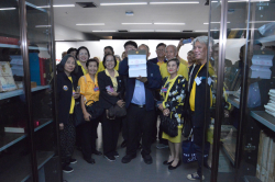 คณะเยี่ยมชมร่วมกันถ่ายภาพเป็นที่ระลึกบริเวณชั้นหนังสือหายาก